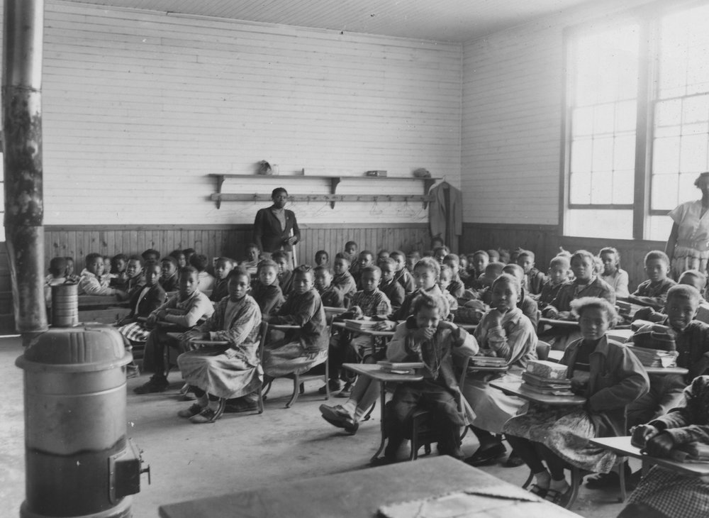 The only heat for students in the Sherman Creek Elementary School in Tallahatchie County in 1955 was the wood heater in the middle of the room.   John E. Phay collection at the University of Mississippi Libraries Digital Collections